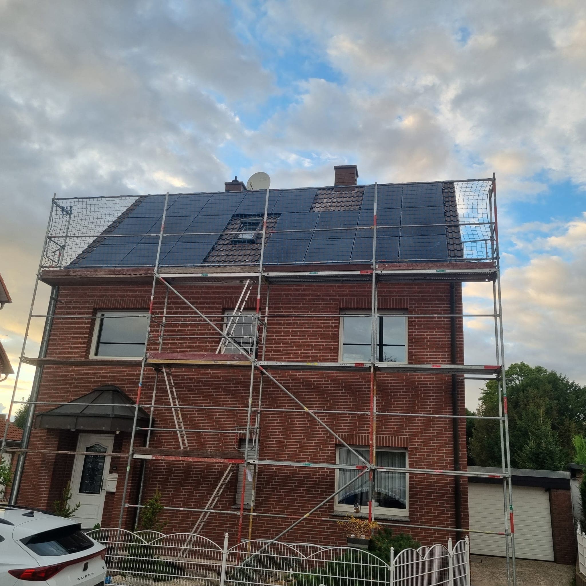 Mehrfamilienhaus aus rotem Klinker mit neuer Photovoltaikanlage auf dem Satteldach